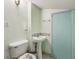 Cozy bathroom with a pedestal sink, mosaic backsplash, toilet, and mint door at 910 E Pike St, Martinsville, IN 46151