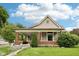 Charming exterior featuring a covered porch with brick columns and a beautifully landscaped front yard at 910 E Pike St, Martinsville, IN 46151
