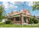 Charming two-story home with a brick-columned front porch and an American flag in a lush, landscaped yard at 910 E Pike St, Martinsville, IN 46151