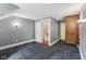 Spacious hallway with unique patterned carpeting, open doorway, and a wooden access door at 910 E Pike St, Martinsville, IN 46151