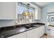 Close up of a kitchen with granite countertops, white cabinets, and a view out of the window at 910 E Pike St, Martinsville, IN 46151