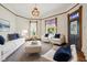 Bright living room featuring neutral walls, hardwood floors, a colorful chandelier and a variety of seating options at 910 E Pike St, Martinsville, IN 46151