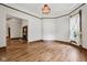 Inviting living room featuring hardwood floors, vintage trim, and decorative light fixture at 910 E Pike St, Martinsville, IN 46151