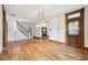 Spacious living room featuring wood floors, a staircase, and a decorative vintage light fixture at 910 E Pike St, Martinsville, IN 46151