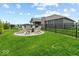 Backyard with green grass, black fencing, and a circular patio with chairs around a fire pit at 920 Alba Dr, Lebanon, IN 46052