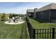The backyard boasts a fire pit surrounded by Adirondack chairs, pool, and lush lawn at 920 Alba Dr, Lebanon, IN 46052