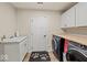 Bright laundry room includes a sink, butcher block folding counter, and side-by-side washer and dryer at 920 Alba Dr, Lebanon, IN 46052