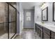 Bathroom featuring a shower with glass door and double vanity with dark cabinets at 952 Workington Cir, Westfield, IN 46074