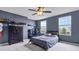 Blue accent wall bedroom featuring a window with blinds, a ceiling fan, and a checkered bed cover at 952 Workington Cir, Westfield, IN 46074