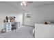 Bright bedroom featuring white vanity desk with lighted mirror and light gray carpet and a ceiling fan at 952 Workington Cir, Westfield, IN 46074