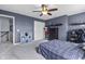 Blue accent wall bedroom featuring a window with blinds, a ceiling fan, and a checkered bed cover at 952 Workington Cir, Westfield, IN 46074