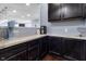 Charming butler's pantry offers sleek countertops, dark cabinetry, and convenient coffee station at 952 Workington Cir, Westfield, IN 46074