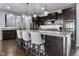 Stylish kitchen featuring dark cabinetry, stainless steel appliances, pendant lighting, and an eat-in island at 952 Workington Cir, Westfield, IN 46074