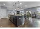 Open-concept kitchen with a large dark-cabinet island, pendant lighting, seamlessly connected to the dining and living areas at 952 Workington Cir, Westfield, IN 46074