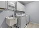Functional laundry room with modern washer, dryer, sink, and overhead storage at 952 Workington Cir, Westfield, IN 46074