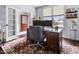 Well-lit office space with a wooden desk, a red door, and a patterned rug at 952 Workington Cir, Westfield, IN 46074