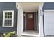Close-up of front porch with dark-stained front door, white columns, and house number at 9613 W Stargazer Dr, Pendleton, IN 46064