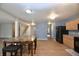 Open-concept kitchen and dining area with wood-look floors and a view of the staircase at 9613 W Stargazer Dr, Pendleton, IN 46064