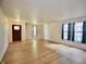 Bright living room with wood-look floors, multiple windows, and a dark-stained front door at 9613 W Stargazer Dr, Pendleton, IN 46064