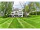 Back of a beautiful home with a large lawn and a deck with an outdoor seating area at 9790 Summerlakes Dr, Carmel, IN 46032