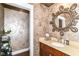 Stylish powder room featuring decorative wallpaper, vanity with marble countertop, and elegant mirror at 9790 Summerlakes Dr, Carmel, IN 46032