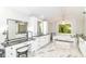 Luxurious bathroom with marble floors, soaking tub, vanity, makeup table, and natural light from the window at 9790 Summerlakes Dr, Carmel, IN 46032