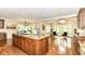 Open-concept kitchen with a large island, hardwood floors, and dining area featuring large windows and elegant chandeliers at 9790 Summerlakes Dr, Carmel, IN 46032