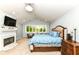 Serene main bedroom featuring a fireplace, vaulted ceiling, large windows, and a cozy sitting area at 9790 Summerlakes Dr, Carmel, IN 46032