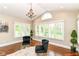 Bright sitting area with vaulted ceilings, chandelier, two chairs, large windows, and a serene outdoor view at 9790 Summerlakes Dr, Carmel, IN 46032
