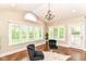 Bright sitting area with vaulted ceilings, chandelier, two chairs, large windows, and a serene outdoor view at 9790 Summerlakes Dr, Carmel, IN 46032