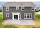 Back exterior featuring gray siding, a concrete patio, and a well-manicured lawn at 9860 Gallop Ln, Fishers, IN 46040