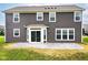 Back exterior featuring a gray siding and a concrete patio surrounded by lush green grass at 9860 Gallop Ln, Fishers, IN 46040