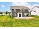 View of backyard showing grey siding, manicured lawn and concrete patio at 9860 Gallop Ln, Fishers, IN 46040