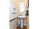 Small powder room with pedestal sink, round mirror and charming decorative towels at 9860 Gallop Ln, Fishers, IN 46040