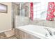 Modern bathroom featuring a soaking tub with tile surround and a separate shower at 9860 Gallop Ln, Fishers, IN 46040