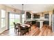 Open dining area with dark wood floors, chandelier, adjacent to a modern kitchen with sliding glass door at 9860 Gallop Ln, Fishers, IN 46040