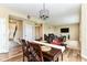 Inviting dining area featuring a chandelier, wood floors, and seamless access to the cozy living room at 9860 Gallop Ln, Fishers, IN 46040