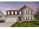 Charming two-story home featuring red shutters, a white garage door, and a well-manicured lawn at 9860 Gallop Ln, Fishers, IN 46040