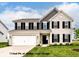 Charming two-story home with brick facade, gray siding, black shutters, and well-manicured lawn at 9860 Gallop Ln, Fishers, IN 46040