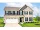 Charming two-story home featuring a brick facade, black shutters, attached garage, and well-manicured front lawn at 9860 Gallop Ln, Fishers, IN 46040