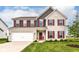 Charming two-story home with light brick, red shutters, a two-car garage, and a well-manicured lawn at 9860 Gallop Ln, Fishers, IN 46040
