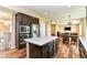 Spacious kitchen island with granite countertop, dark cabinets, and stainless steel appliances nearby at 9860 Gallop Ln, Fishers, IN 46040