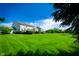 Expansive backyard with lush lawn, mature trees, deck, and serene pond view at 10075 Niagara Dr, Fishers, IN 46037