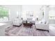 Open-concept living room with a gray couch and neutral decor, bathed in natural light from large windows at 10075 Niagara Dr, Fishers, IN 46037