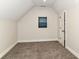 Attic bedroom with gray carpet and a small window, perfect for a cozy retreat at 1043 N Beville Ave, Indianapolis, IN 46201