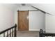 Upstairs hallway with neutral paint and carpet featuring a wooden sliding barn door at 1043 N Beville Ave, Indianapolis, IN 46201