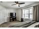 Well-lit bedroom with ceiling fan, TV, large window, and neutral carpet at 10551 Huckleberry Ct, Noblesville, IN 46060
