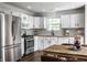 Bright eat-in kitchen features white cabinets, stainless appliances, butcher block countertops and subway tile backsplash at 10551 Huckleberry Ct, Noblesville, IN 46060