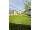 Wide shot of the backyard with a fire pit, lush lawn, garden, and a view of the house at 106 S Denny St, Indianapolis, IN 46201