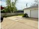 Spacious concrete patio area next to a detached garage and partially fenced yard at 106 S Denny St, Indianapolis, IN 46201